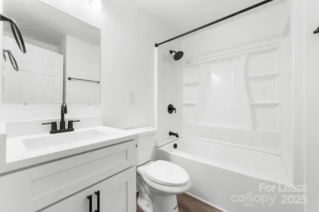 a bathroom with a granite countertop sink a toilet and a mirror
