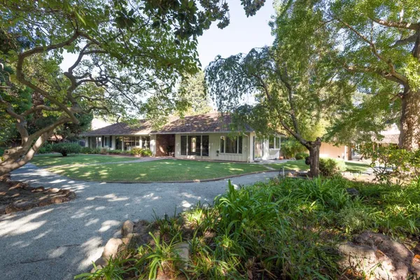 a front view of a house with yard and green space