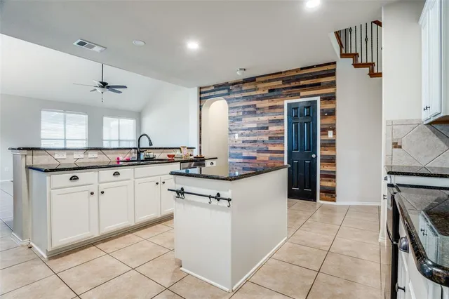 a kitchen with stainless steel appliances granite countertop a sink and a refrigerator