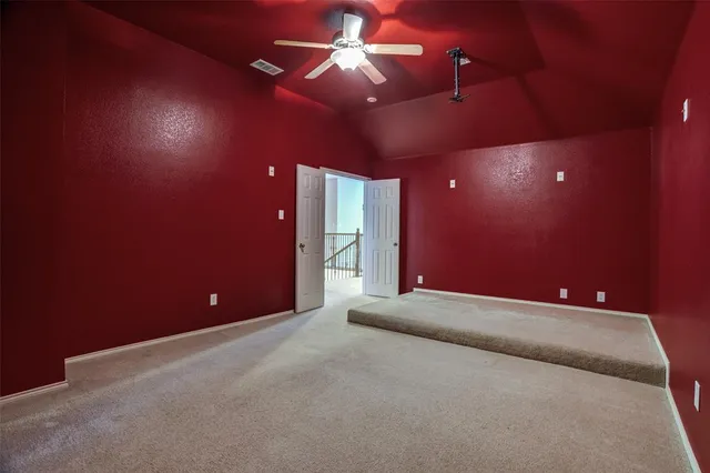 a view of an empty room with a ceiling fan and window