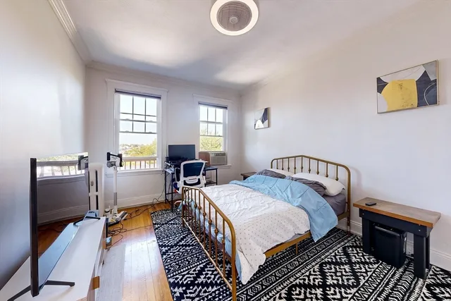 a bedroom with a bed and wooden floor