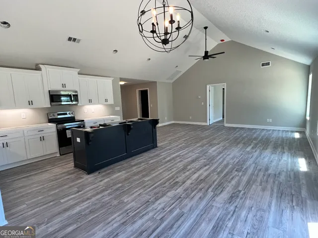 a kitchen with stainless steel appliances granite countertop a stove and a wooden floors