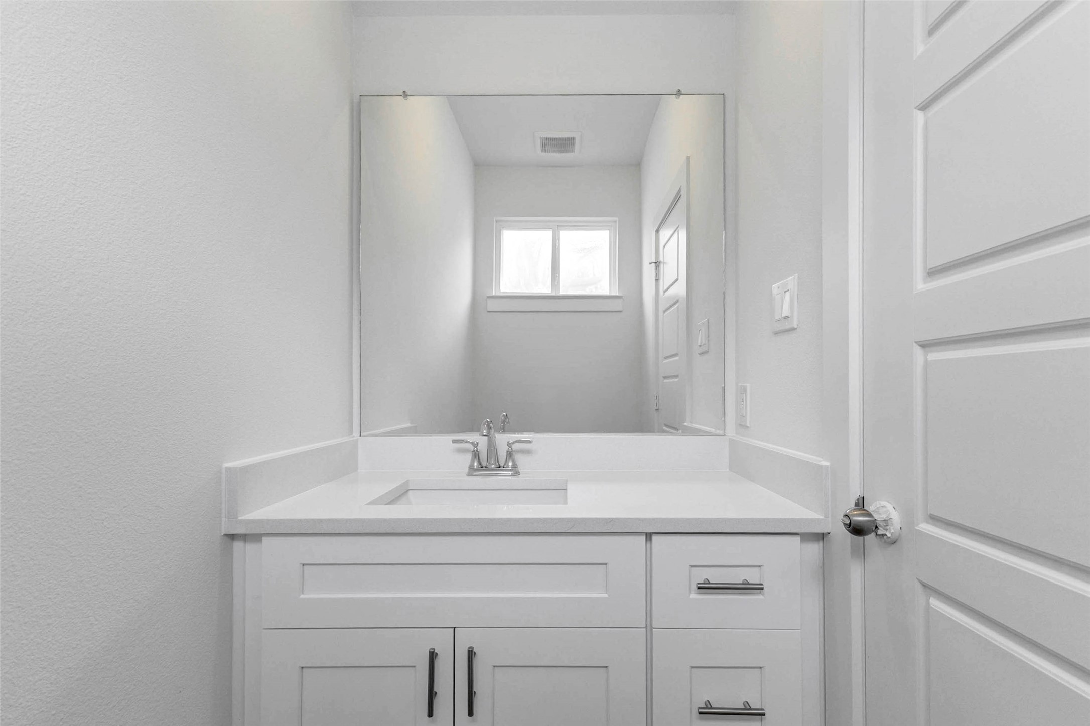 6471 Escondido Drive Rosharon, TX 77583 - Photo 17 of 33 Clean powder bath with white vanity, quartz-style countertop, undermount sink, chrome faucet, large wall mirror, neutral walls, and simple modern finishes. This conveniently located half bath provides a polished guest-friendly feature on the main level with a bright and streamlined design.