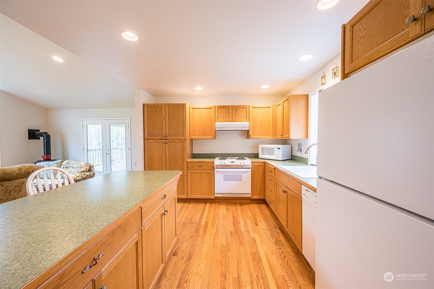 1545 Ripley Creek Road Quilcene, WA 98376 - Photo 18 of 23 a kitchen with kitchen island granite countertop a sink and wooden cabinets