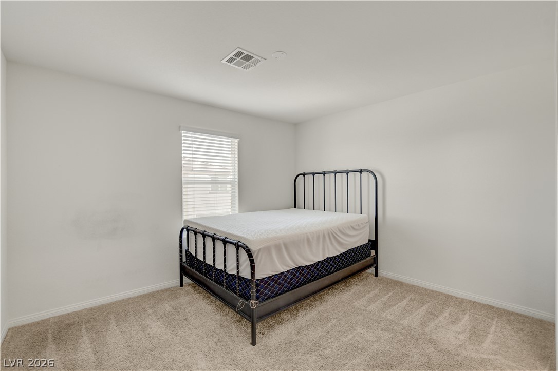 6924 Spicy Merlot Street North Las Vegas, NV 89086 - Photo 29 of 83 A well-lit bedroom features plush carpeting and a bright window.