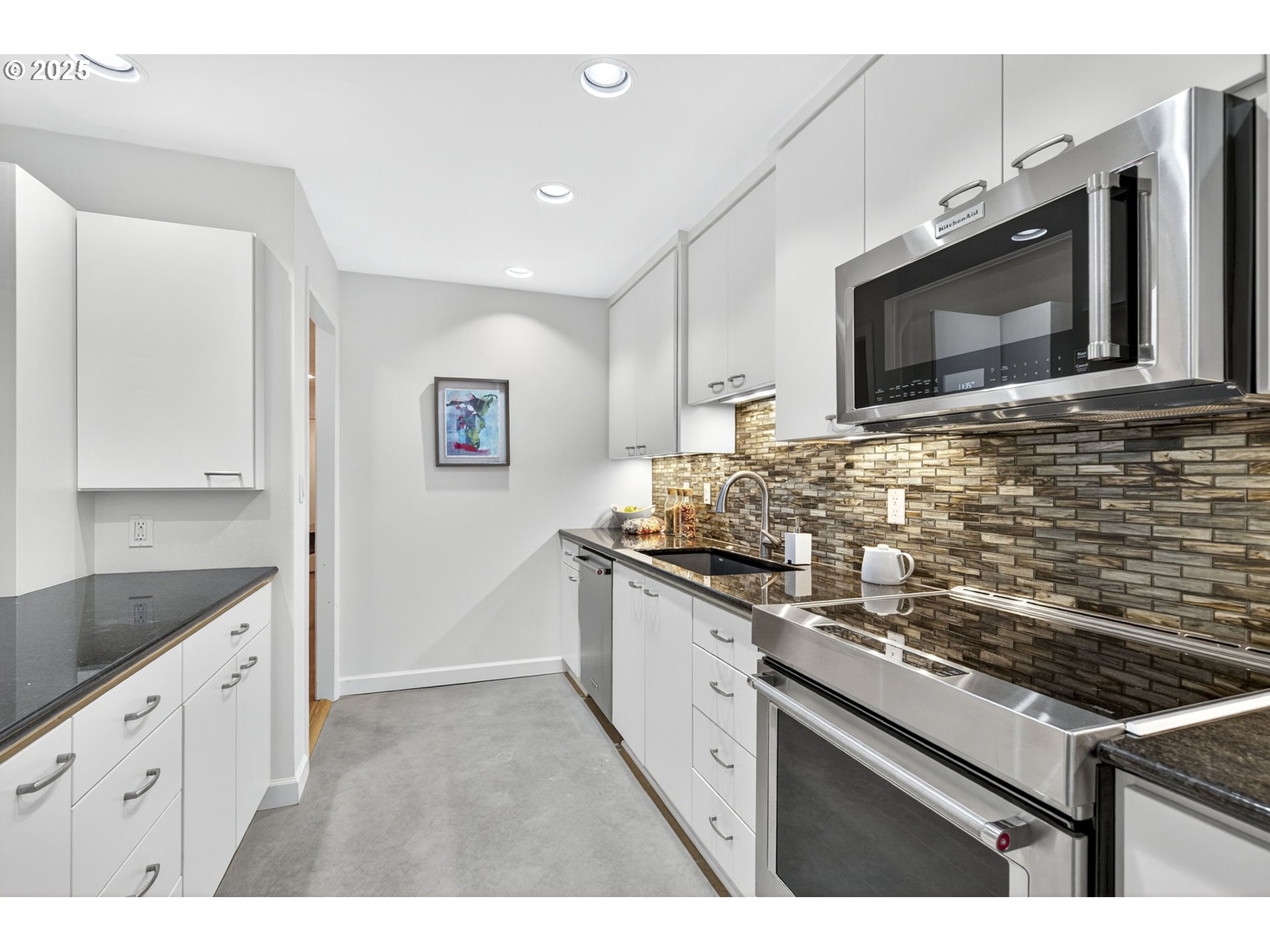 2309 Southwest 1st Avenue, Unit G41 Portland, OR 97201 - Photo 27 of 44 a kitchen with stainless steel appliances granite countertop a stove and a microwave