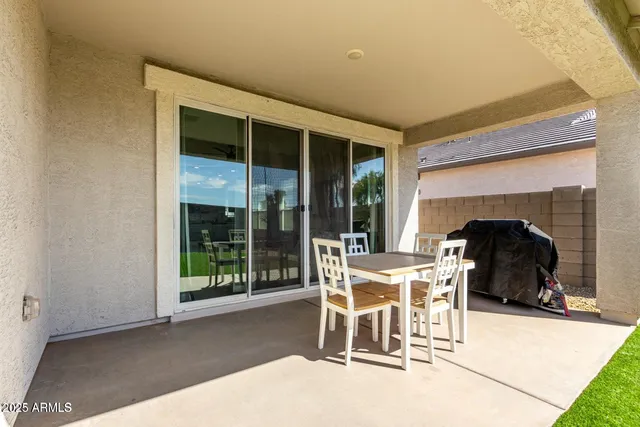 a dining room with furniture and a floor to ceiling window