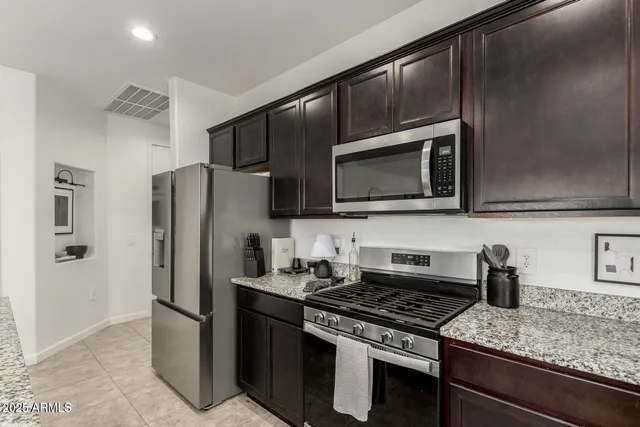 a kitchen with stainless steel appliances granite countertop a refrigerator stove and microwave