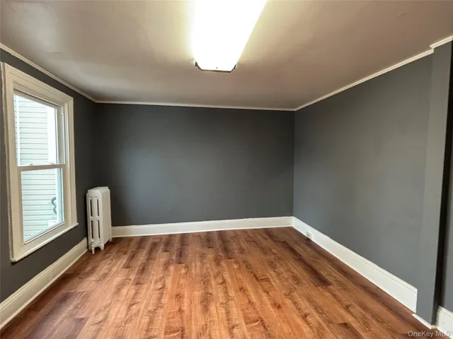 a view of a room with wooden floor and white walls