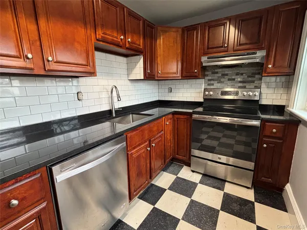 a kitchen with stainless steel appliances granite countertop a sink stove and cabinets