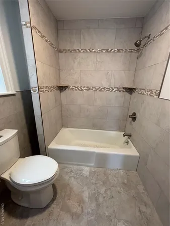 a white toilet sitting next to a bath tub and a shower