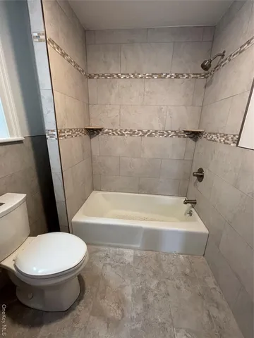 a white toilet sitting next to a bath tub and a shower