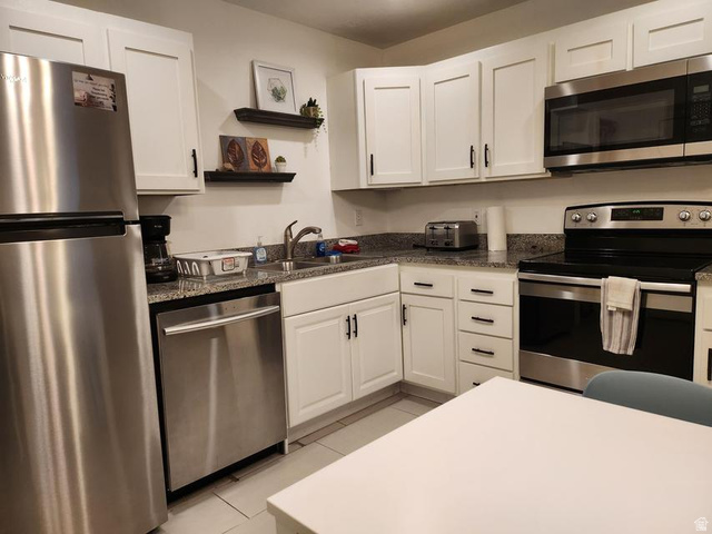 860 South Village Road, Unit H1 St. George, UT 84770 - Photo 2 of 20 Kitchen featuring stainless steel appliances, white cabinetry, open shelves, and dark stone counters
