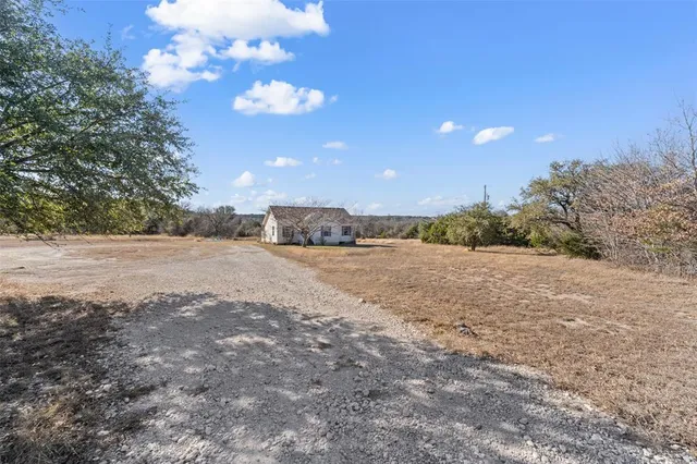 a view of dirt road with a building
