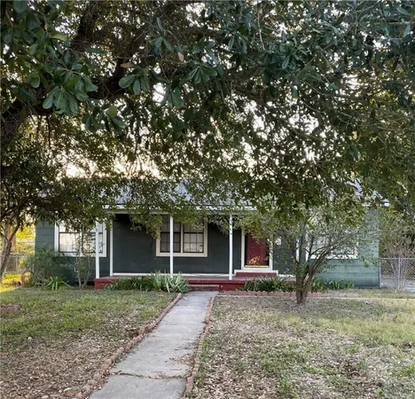 a front view of a house with a garden and trees