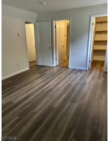 a view of empty room with wooden floor and closet