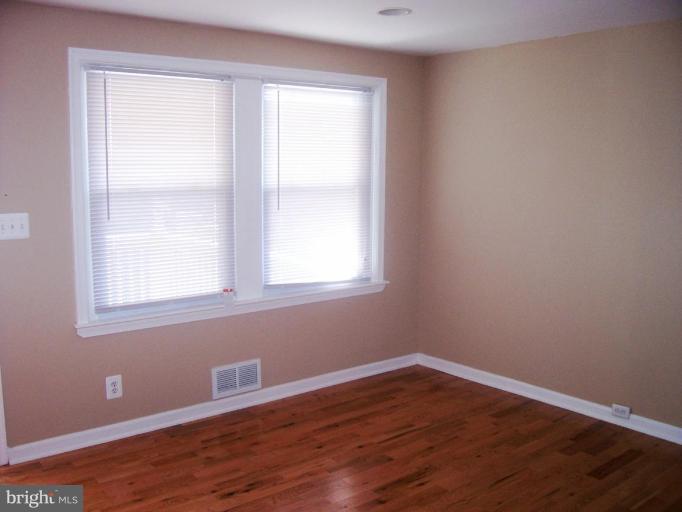 2462 Nevada Street Baltimore, MD 21230 - Photo 3 of 22 a view of an empty room with wooden floor and a window