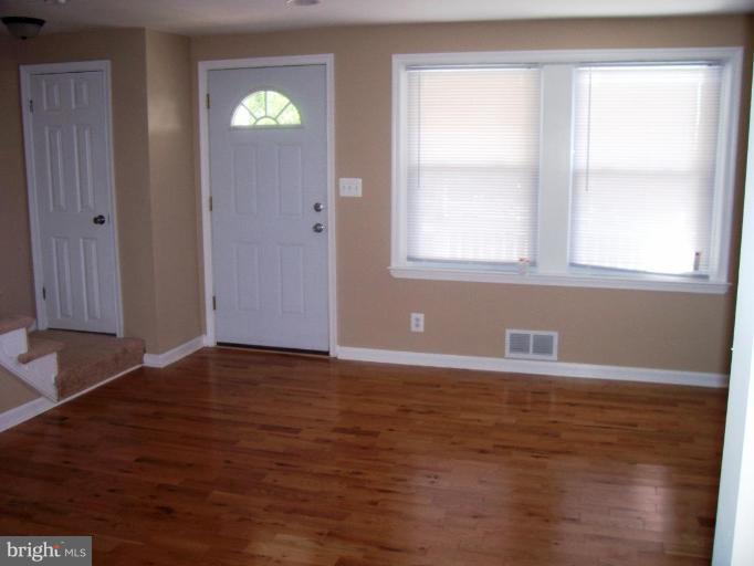 2462 Nevada Street Baltimore, MD 21230 - Photo 4 of 22 a view of an empty room with window and wooden floor