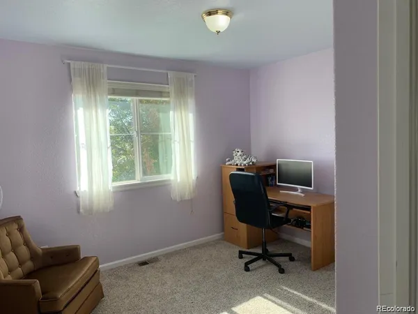 a view of a workspace with furniture and a window