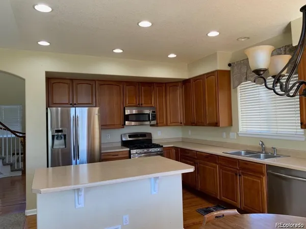 a kitchen with kitchen island a sink stainless steel appliances and cabinets