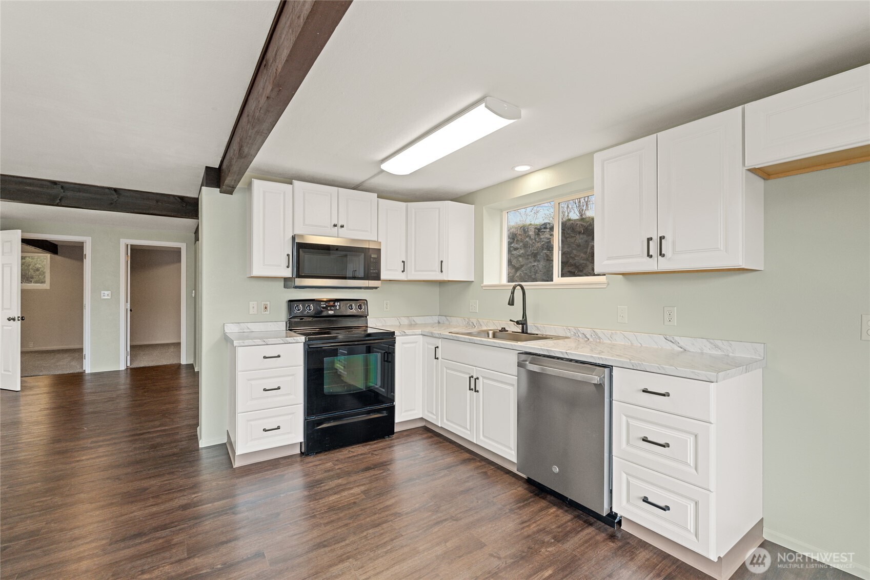 314 West 3rd Street Omak, WA 98841 - Photo 12 of 28 a kitchen with stainless steel appliances granite countertop a stove top oven a sink dishwasher and a refrigerator with wooden floor