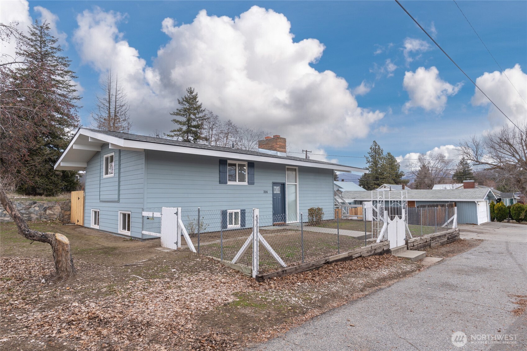 314 West 3rd Street Omak, WA 98841 - Photo 3 of 28 a view of a house with a backyard and a tree