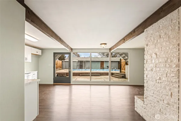 a living room with stainless steel appliances kitchen island wooden floors and fireplace