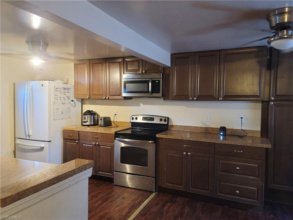 404 Center Road Fort Myers, FL 33907 - Photo 7 of 11 a kitchen with granite countertop wooden cabinets and stainless steel appliances