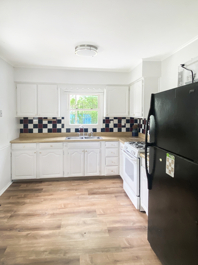 Undisclosed Address Round Lake Beach, IL 60073 - Photo 2 of 10 a large white kitchen with stainless steel appliances a sink a stove a microwave a counter top space and cabinets