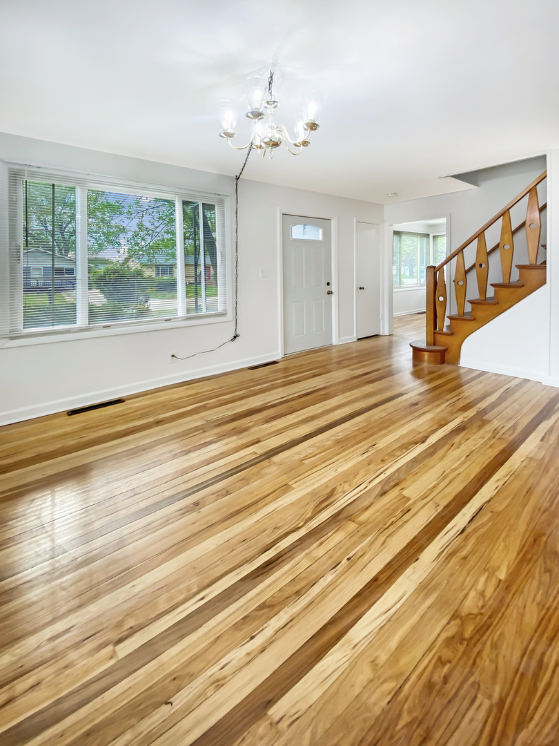 Undisclosed Address Round Lake Beach, IL 60073 - Photo 4 of 10 a view of an empty room with wooden floor and a window