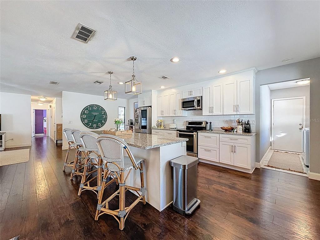 7813 River Ridge Drive Temple Terrace, FL 33637 - Photo 11 of 43 a kitchen with stainless steel appliances a dining table chairs stove and white cabinets
