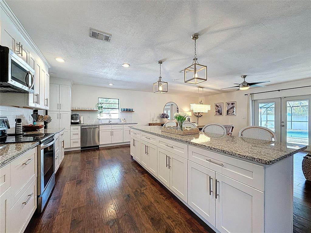 7813 River Ridge Drive Temple Terrace, FL 33637 - Photo 13 of 43 a kitchen with kitchen island granite countertop stainless steel appliances lots of counter space sink and cabinets