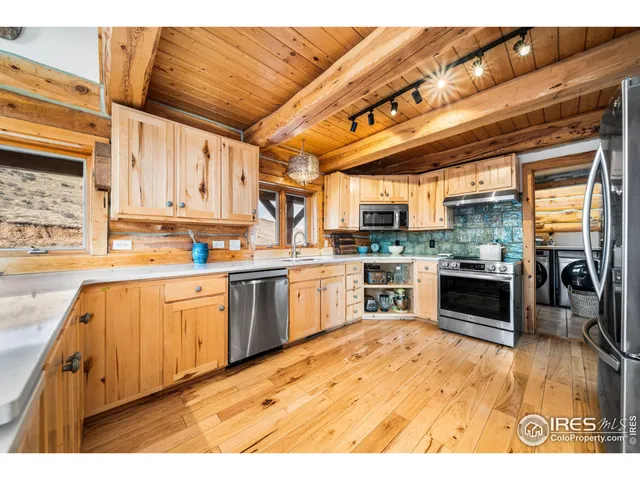 a kitchen with a sink and wooden floor