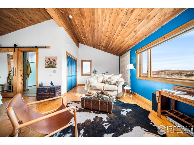 a living room with furniture a flat screen tv and a large window
