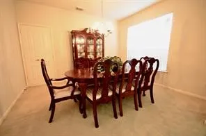 a view of a dining room and livingroom furniture wooden floor a chandelier