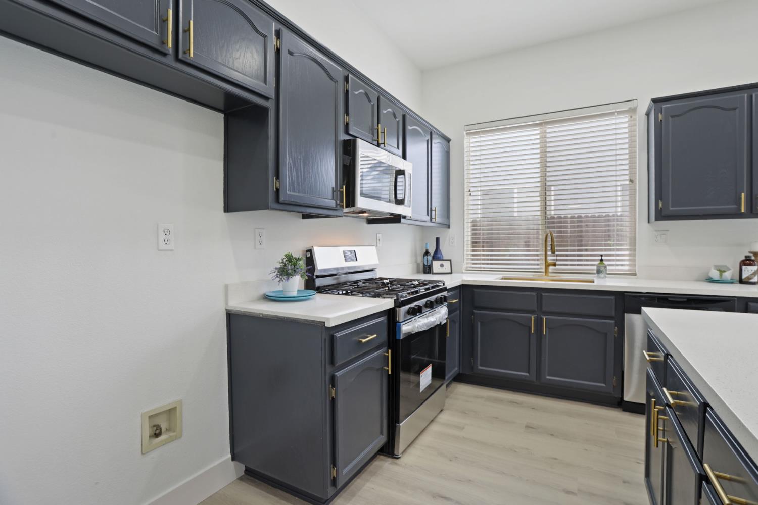 1829 Nighthawk Circle Roseville, CA 95661 - Photo 16 of 34 a kitchen with stainless steel appliances granite countertop a stove a sink dishwasher and a microwave oven with wooden cabinets
