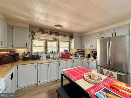 a kitchen that has a lot of cabinets a sink and appliances in it