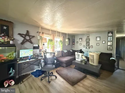 a living room with furniture a flat screen tv and a window