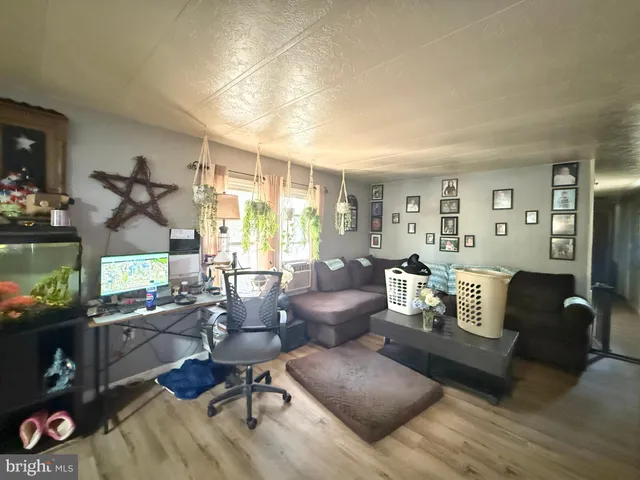 a living room with furniture a flat screen tv and a window