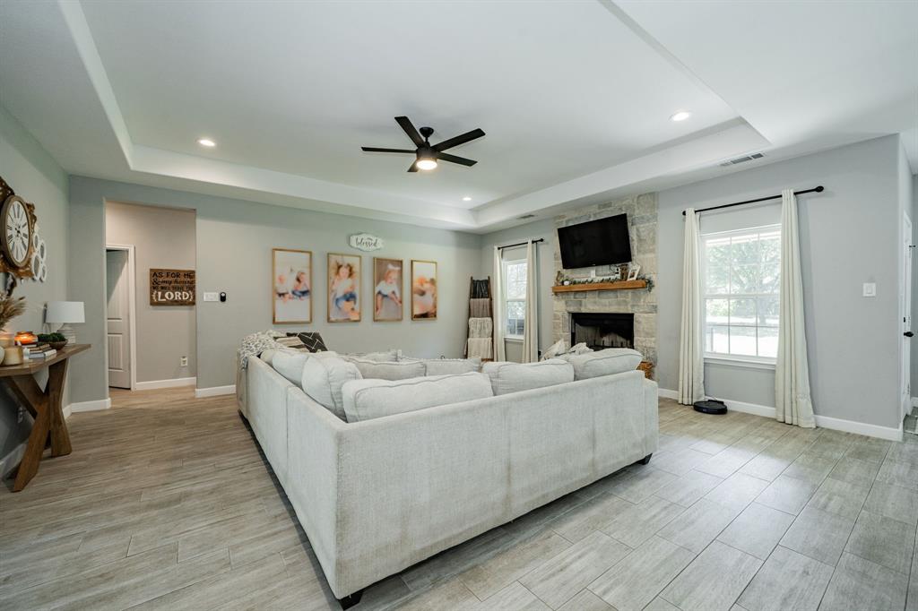 7679 Caddo Creek Road Quinlan, TX 75474 - Photo 8 of 28 a living room with furniture a fireplace and a flat screen tv