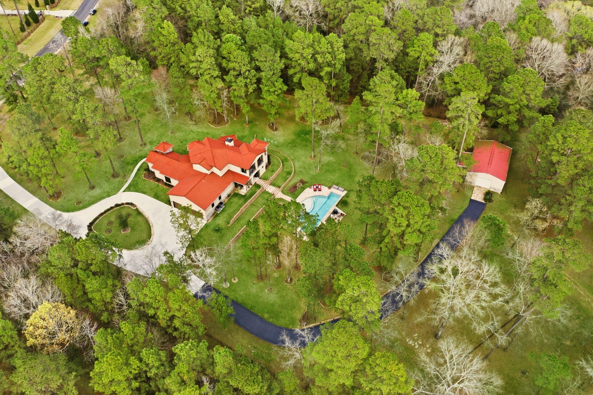 280 Sundog Road Huntsville, TX 77340 - Photo 5 of 50 Aerial view showcasing the home, circular driveway, and drive leading to the workshop, surrounded by the natural beauty of the wooded acreage.