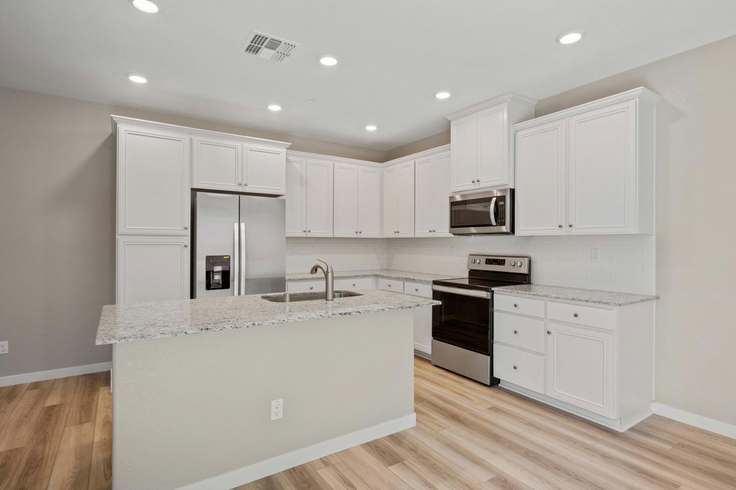 2979 Bowery Lane Lincoln, CA 95648 - Photo 9 of 19 a kitchen with kitchen island a white cabinets and stainless steel appliances