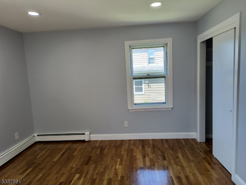 85 Grove Street South Hackensack, NJ 07606 - Photo 12 of 32 an empty room with wooden floor and windows