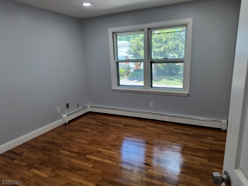 85 Grove Street South Hackensack, NJ 07606 - Photo 6 of 32 an empty room with wooden floor and windows