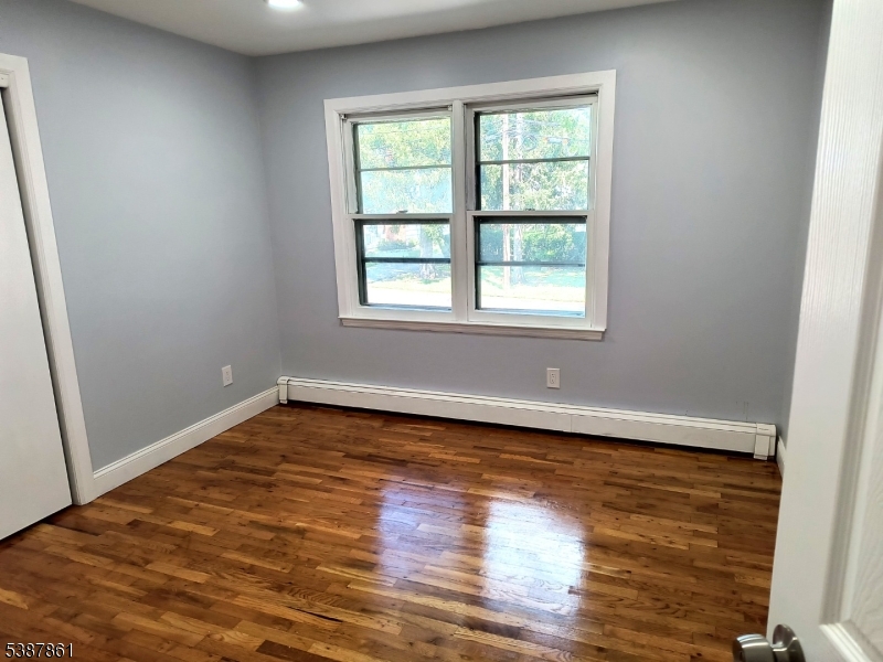 85 Grove Street South Hackensack, NJ 07606 - Photo 8 of 32 an empty room with wooden floor and windows