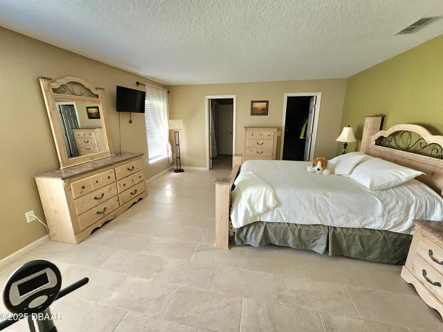 a bedroom with a bed and a tv on the dresser