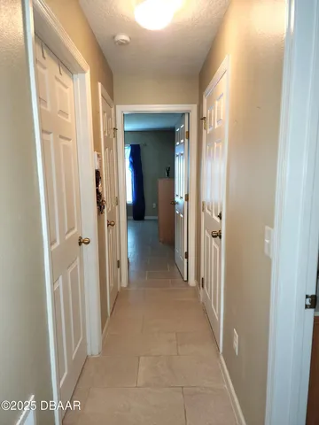 a view of a hallway with wooden floor and closet area