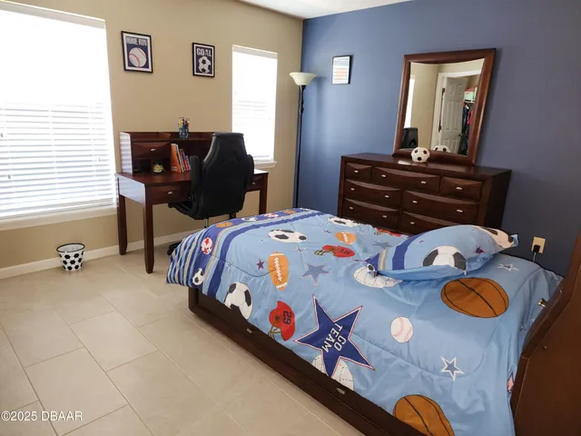 a bedroom that has two beds and a table in it