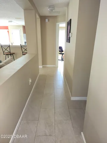 a view of a hallway to rooms and stairs