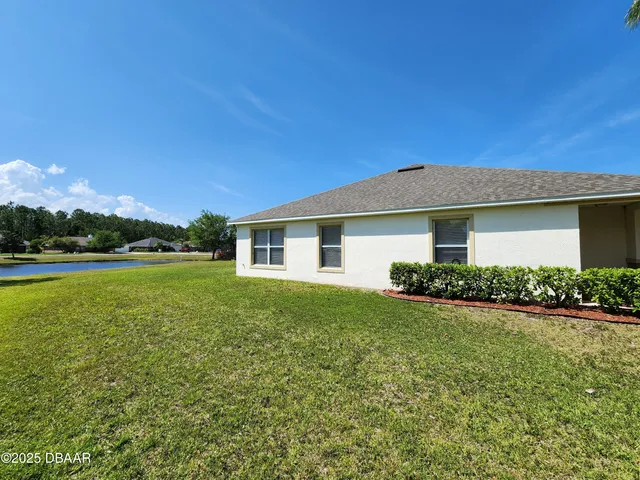 a view of a house with garden and a yard
